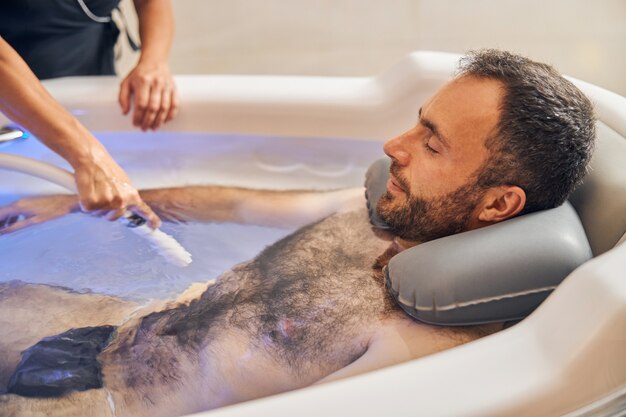 bearded-gentleman-relaxing-bathtub-while-female-beautician-performing-underwater-massage-with-special-device_447912-6175 bearded-gentleman-relaxing-bathtub-while-female-beautician-performing-underwater-massage-with-special-device_447912-6175